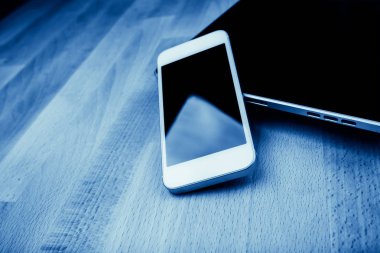 Ahşap masa üzerinde telefon ve tablet pc ile klavye