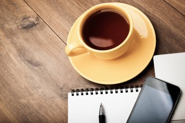 İşyeri ile telefon, defter, kalem ve kahve üzerinde çalışma tablosu Üstten Görünüm