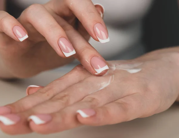 Las manos de la mujer aplicando crema — Foto de Stock