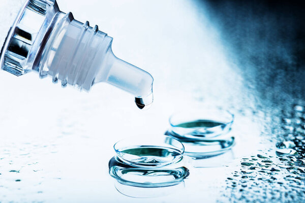 Bottle with lens solution and case on tabl