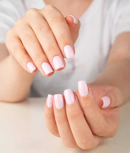 Женская рука с светло-розовым дизайном ногтей — стоковое фото