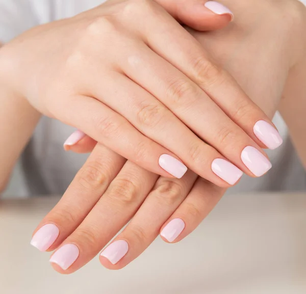 Жіноча рука з світло-рожевим дизайном нігтів — стокове фото