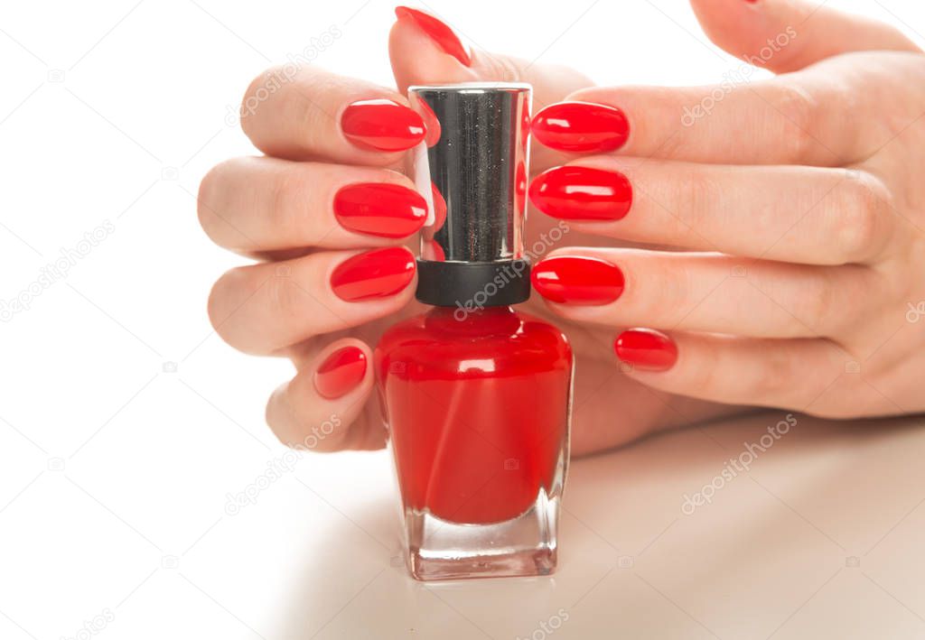 Female hand with red nail polish bottl