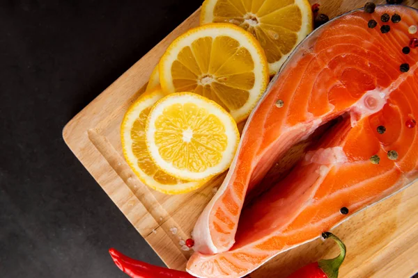 Raw salmon fillets, pepper and lemon — Stock Photo, Image