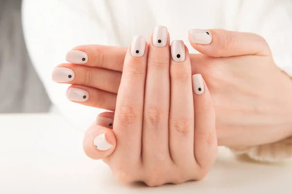 Mão com manicure bege com design de unhas pontos — Fotografia de Stock