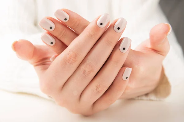 Mão com manicure bege com design de unhas pontos — Fotografia de Stock