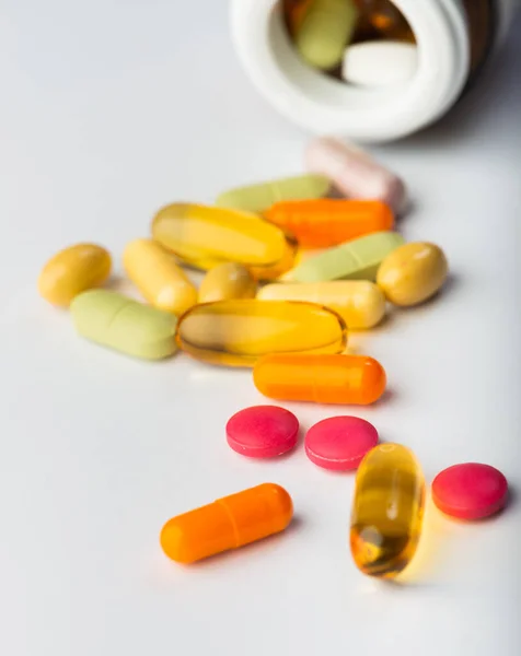 Pílulas Medicina Farmacêutica Sortidas Derramando Uma Garrafa Fundo Branco — Fotografia de Stock