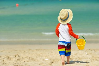 Sahilde plaj oyuncakları ile oynarken iki yaşında bir yürümeye başlayan çocuk 