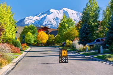 Sonbaharda Colorado, ABD 'deki yerleşim bölgesinde sokak tabelasında yavaş çocuklar. Sopris Dağı manzarası.