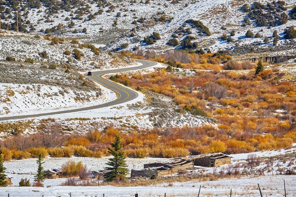 Season changing, first snow and autumn trees along highway in Colorado, USA.