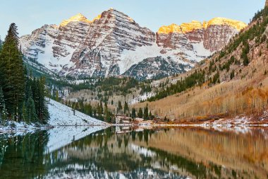 Kestane rengi çan ve Maroon Gölü yansıma kayalar ve karda dağ Güneş doğarken sonbahar içinde Colorado Rocky Dağları, ABD ile. 