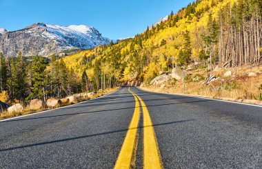 Rocky Dağı Ulusal Parkı 'nda sonbahar güneşli bir günde otoyol. Colorado, ABD