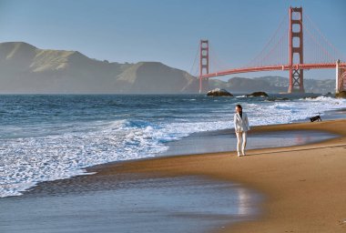 Golden Gate Köprüsü San Francisco, California, ABD yakınlarında Baker sahilde yürüyen kadın.
