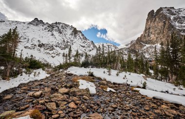 Karlı manzara kayalar ve kar sonbahar bulutlu gökyüzü ile dağlarda. Rocky Dağı Milli Parkı, Colorado, ABD. 