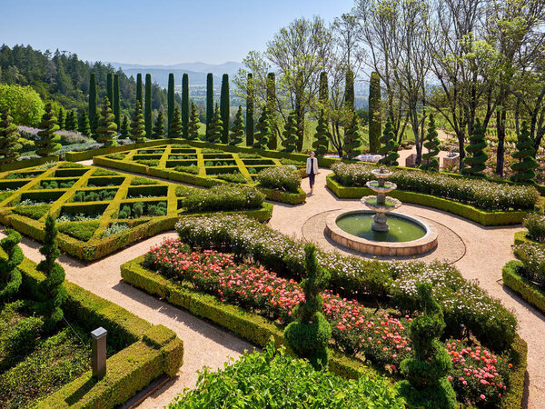 Woman tourist at formal garden in California vineyards, USA. 