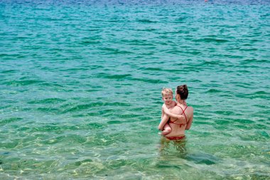 Annesiyle plajda iki yaşında bir çocuk. 