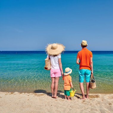 Sahilde bir aile, üç yaşında oğlu olan genç bir çift. Sithonia, Yunanistan