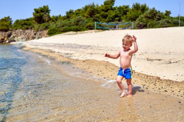 Sahilde iki yaşında bir yürümeye başlayan çocuk 