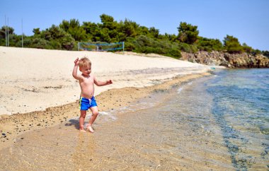 Sahilde iki yaşında bir yürümeye başlayan çocuk 