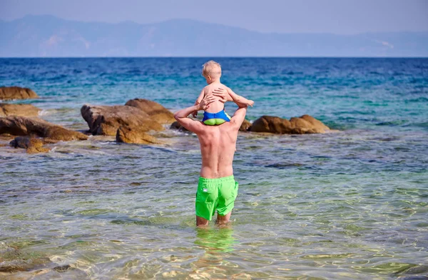两岁的幼儿男孩在海滩上站在父亲的肩膀上 — 图库照片
