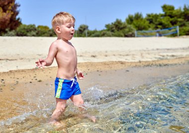 Sahilde yürümeye başlayan çocuk 