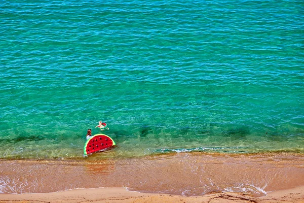 Garçon et sa mère sur la plage avec flotteur gonflable — Photo