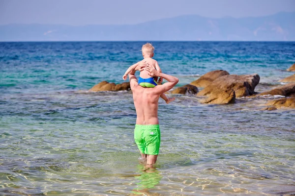 Bambino ragazzo sulle spalle del padre in spiaggia — Foto Stock
