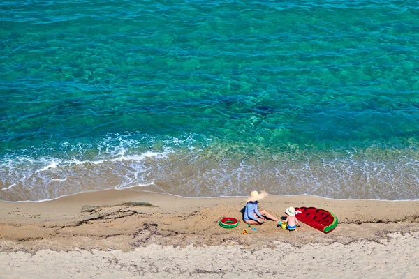 Garçon et sa mère sur la plage avec flotteur gonflable — Photo