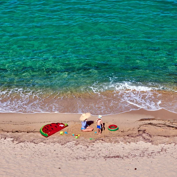 Garçon et sa mère sur la plage avec flotteur gonflable — Photo