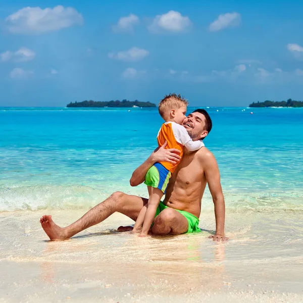 Toddler chłopiec na plaży całuje ojca — Zdjęcie stockowe