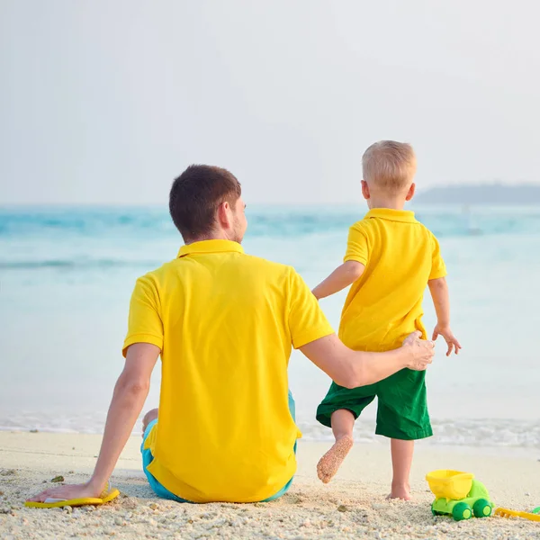 Babası ile sahilde yürümeye başlayan çocuk — Stok fotoğraf