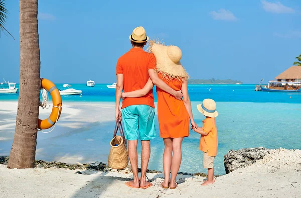 Família de três na praia sob palmeira — Fotografia de Stock