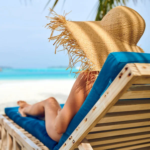 Femme à la plage sur chaises longues en bois — Photo