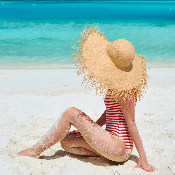 Vrouw in een stuk zwembroek op het strand — Stockfoto