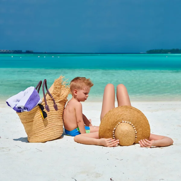 Mujer con niño de tres años en la playa — Foto de Stock