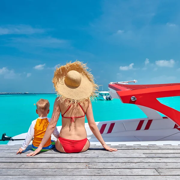 Toddler boy with mother sitting on wooden jetty — Stock Photo, Image