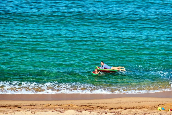 Chłopiec i jego matka na plaży z float nadmuchiwane — Zdjęcie stockowe