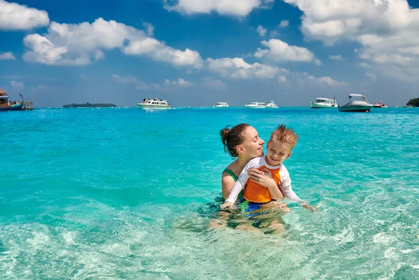 Toddler boy on beach with mother — Stock Photo, Image