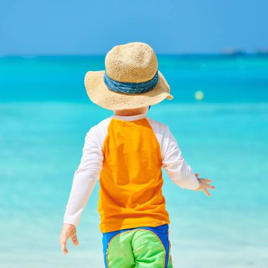 Plajda üç yaşında bir yürümeye başlayan çocuk