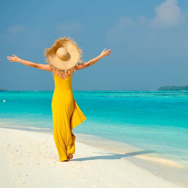 Vrouw in jurk lopen op tropisch strand — Stockfoto