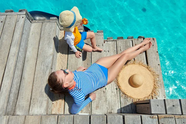 Bambino con madre seduta sul pontile di legno — Foto Stock