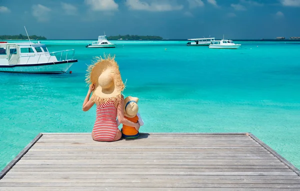 Ahşap iskele üzerinde oturan annesi ile yürümeye başlayan çocuk — Stok fotoğraf