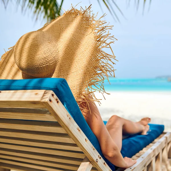 Vrouw aan het strand op houten ligstoelen bed — Stockfoto