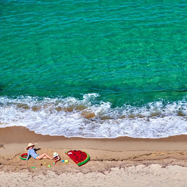 Jongen en zijn moeder op het strand met opblaasbare float — Stockfoto