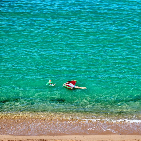 Garçon et sa mère sur la plage avec flotteur gonflable — Photo