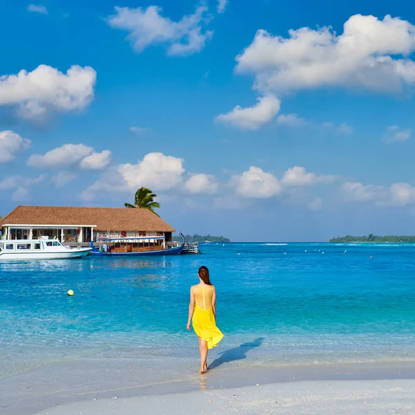 Vrouw in jurk lopen op tropisch strand — Stockfoto