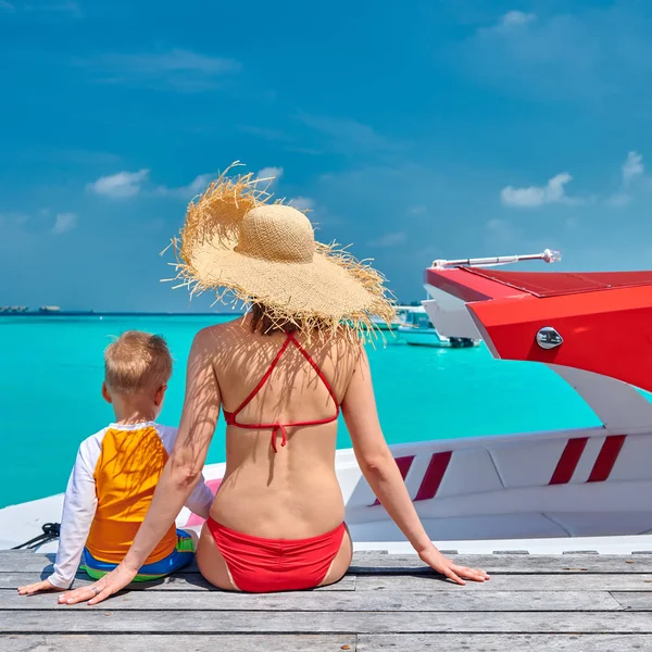 Toddler boy with mother sitting on wooden jetty — Stock Photo, Image