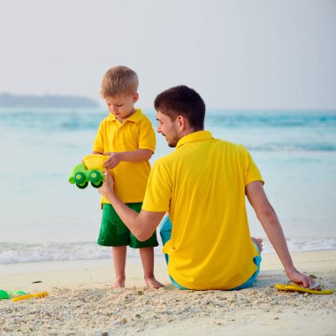 Babası ile sahilde yürümeye başlayan çocuk