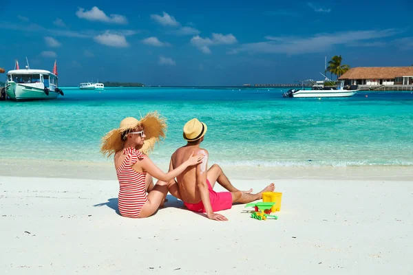 Woman applying sun screen lotion on man's back — Stock Photo, Image