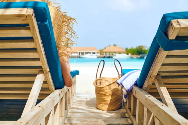 Donna in spiaggia su lettini in legno — Foto Stock